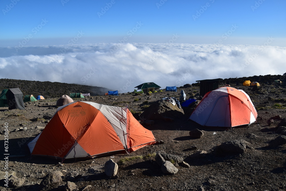 Camping in an orange tent on the Lemosho route while trekking Mount Kilimanjaro in Tanzania
