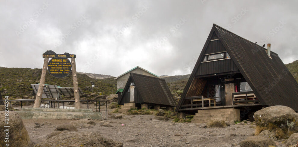 Mountain cabins and trail marker sign on a plateau campsite