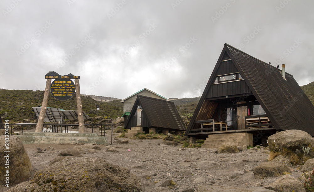 Mountain cabins and trail marker sign on a plateau campsite
